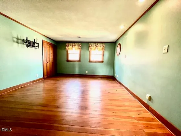 a large room with wooden floor and cabinets