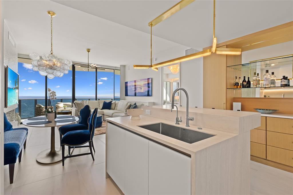 900 North Ocean Boulevard, Unit LPH05 Pompano Beach, FL 33062 - Photo 13 of 69 a kitchen with stainless steel appliances granite countertop a sink a stove and a wooden floors