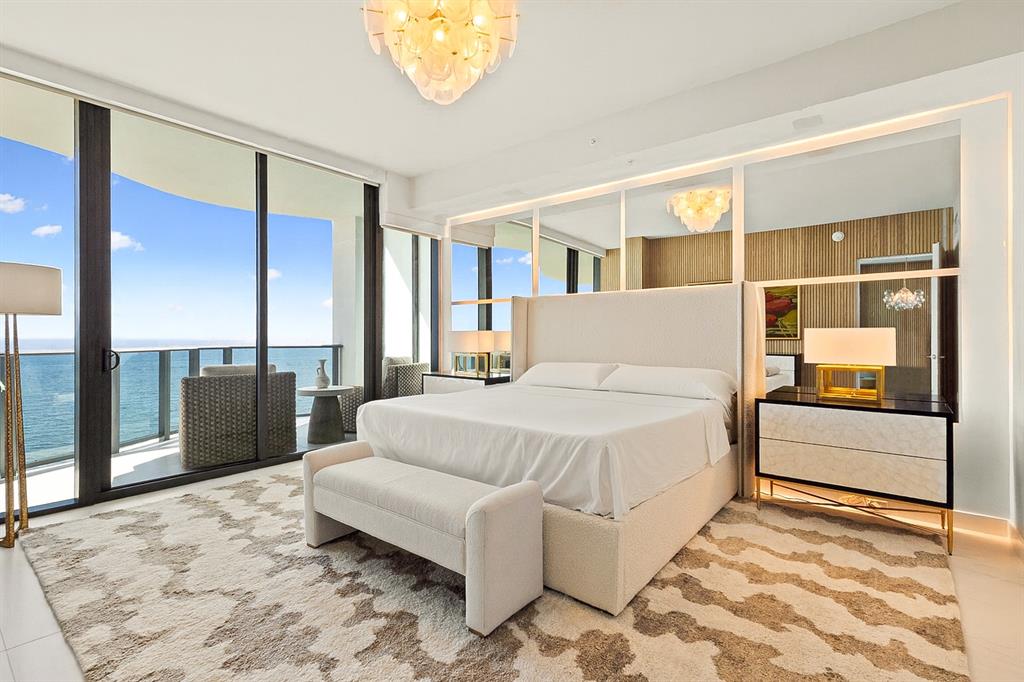 900 North Ocean Boulevard, Unit LPH05 Pompano Beach, FL 33062 - Photo 16 of 69 a spacious bedroom with a large bed and a chandelier