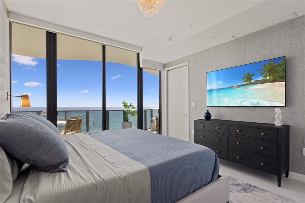 900 North Ocean Boulevard, Unit LPH05 Pompano Beach, FL 33062 - Photo 25 of 69 a bedroom with a bed and a flat screen tv