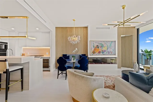 a living room with furniture a dining table and a chandelier