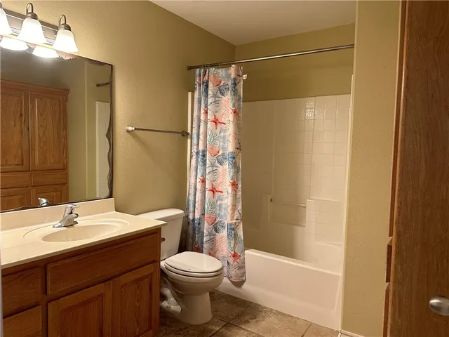 a bathroom with a bathtub shower sink vanity and toilet