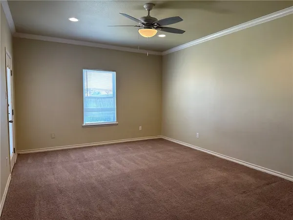 an empty room with ceiling fan and window