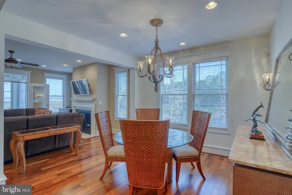 a dining room with furniture a chandelier and wooden floor