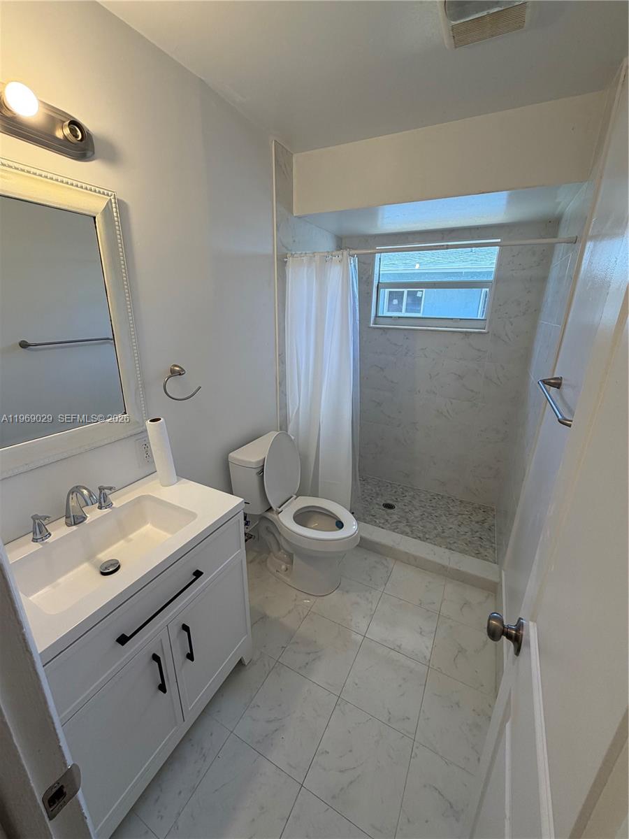 356 Southwest 2nd Place Pompano Beach, FL 33060 - Photo 11 of 23 a bathroom with a double vanity sink toilet and shower