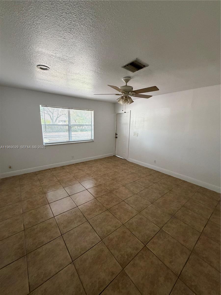 356 Southwest 2nd Place Pompano Beach, FL 33060 - Photo 5 of 23 an empty room with windows and ceiling fan