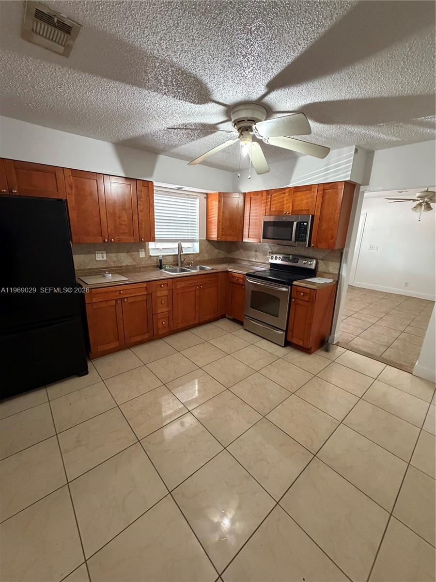 356 Southwest 2nd Place Pompano Beach, FL 33060 - Photo 6 of 23 a kitchen with stainless steel appliances granite countertop a sink and a counter top space