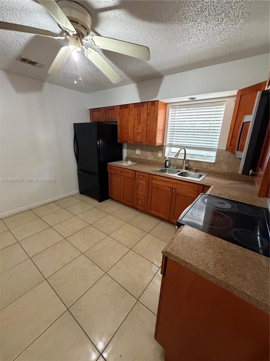 356 Southwest 2nd Place Pompano Beach, FL 33060 - Photo 7 of 23 a kitchen with stainless steel appliances granite countertop a sink and a refrigerator