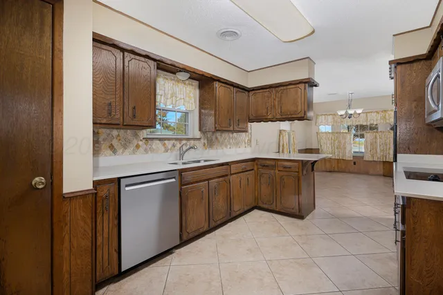 a view of a livingroom with an empty space & a workspace