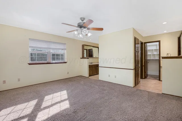 an empty room with closet and ceiling fan