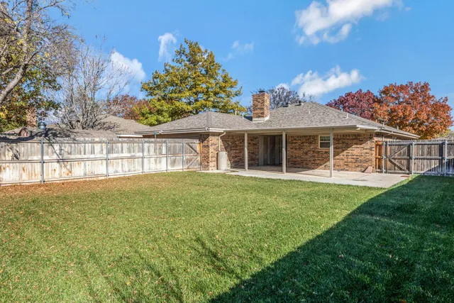 a view of a backyard with wooden fence