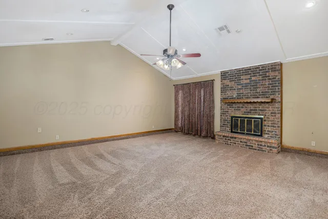 an empty room with windows and fireplace