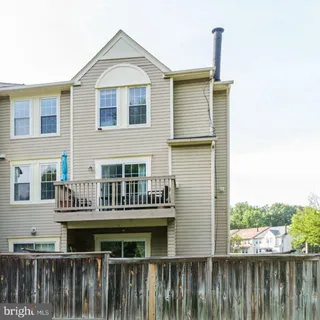 a view of a house with wooden deck and furniture