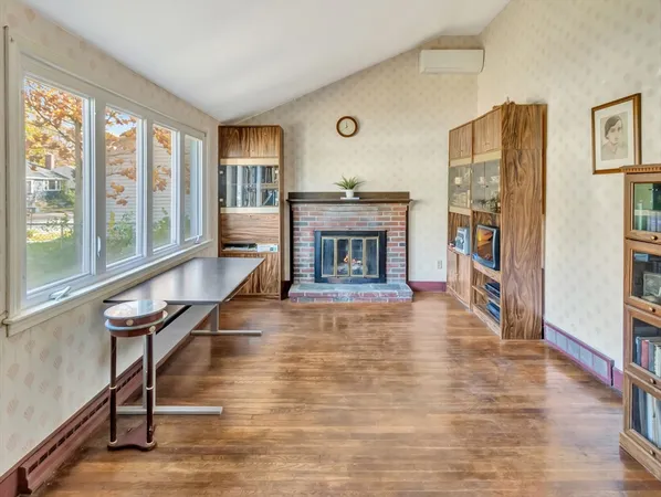a living room with furniture a fireplace and a large window