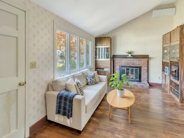 a living room with furniture a large window and a fireplace
