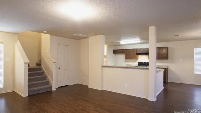 a view of a kitchen with wooden floor and electronic appliances