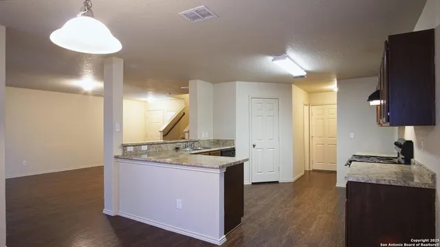 a kitchen with a stove cabinets and wooden floor