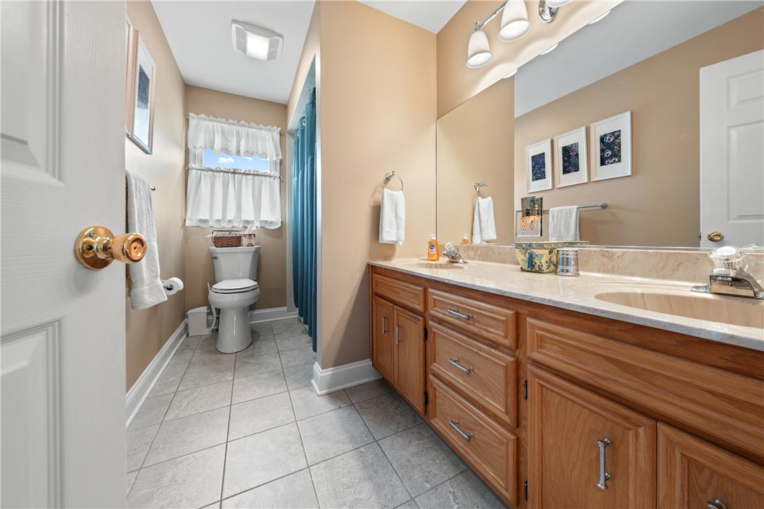 4568 Greenfield Road Bethlehem, PA 18017 - Photo 34 of 59 A well-appointed bathroom features a double vanity and sleek tiled flooring.