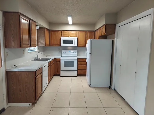 a kitchen with stainless steel appliances granite countertop a refrigerator and a sink