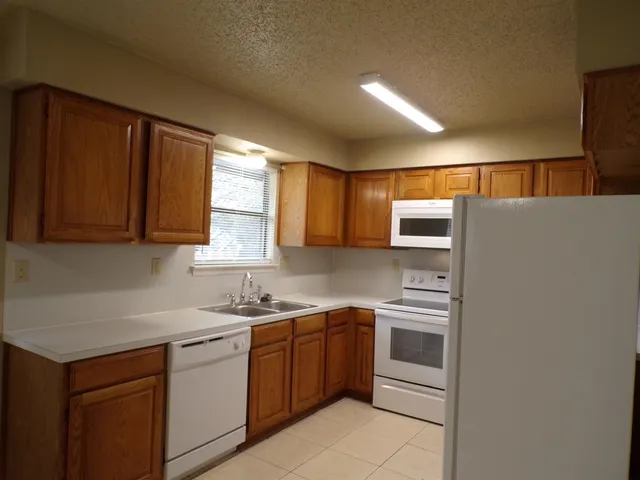 a kitchen with a sink window and cabinets