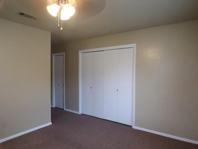 an empty room with a chandelier fan