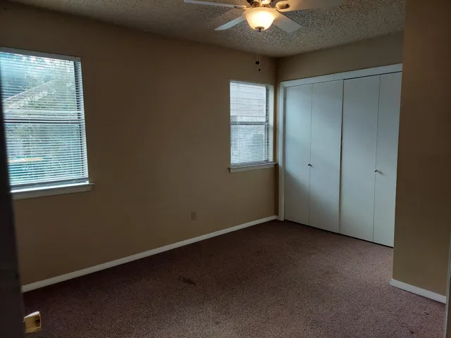 an empty room with windows and closet