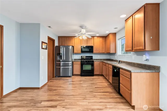 a kitchen with stainless steel appliances granite countertop a refrigerator and a stove top oven