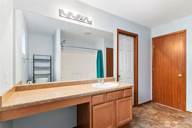a bathroom with a granite countertop sink and a mirror