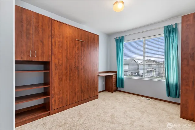 a view of an empty room with a window and closet