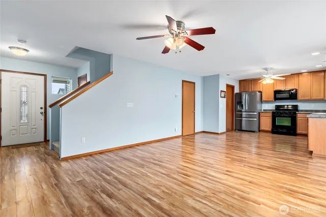 a view of empty room with wooden floor and ceiling fan
