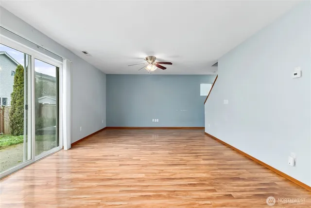 a view of a room with a ceiling fan and wooden floor