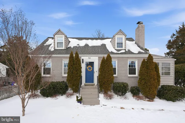 a front view of a house with a yard covered in snow