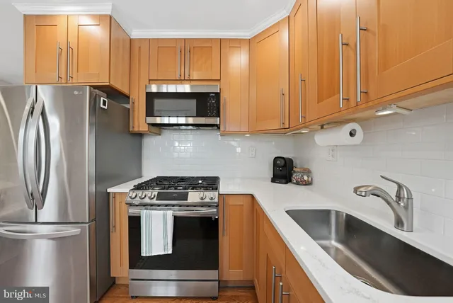 a kitchen with stainless steel appliances granite countertop a refrigerator sink and microwave