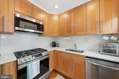 a kitchen with stainless steel appliances a stove a microwave sink and cabinets