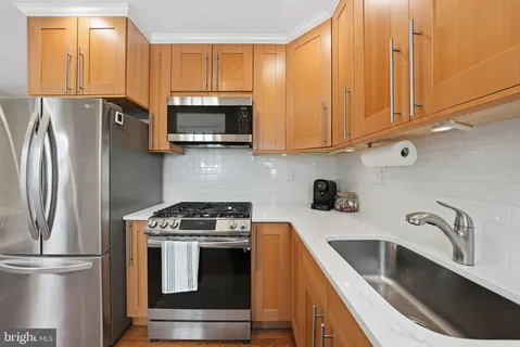 a kitchen with stainless steel appliances granite countertop a refrigerator sink and microwave