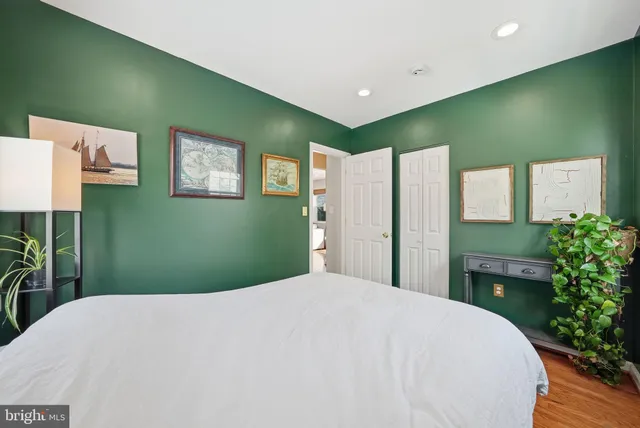 a bedroom with a large bed and a potted plant