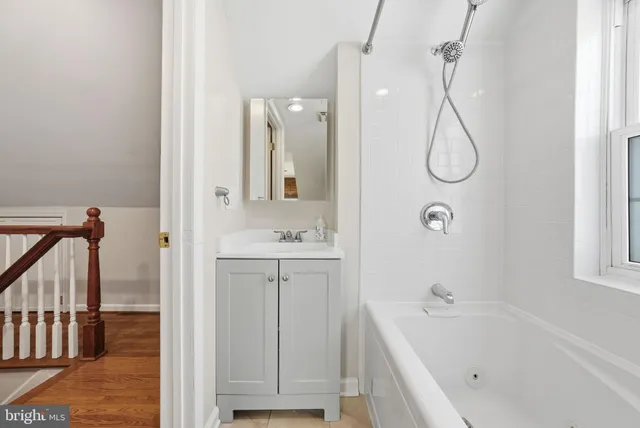 a bathroom with a tub sink and mirror