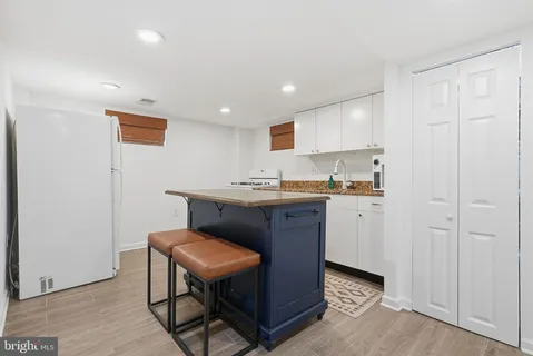 a kitchen with a sink cabinets and wooden floor