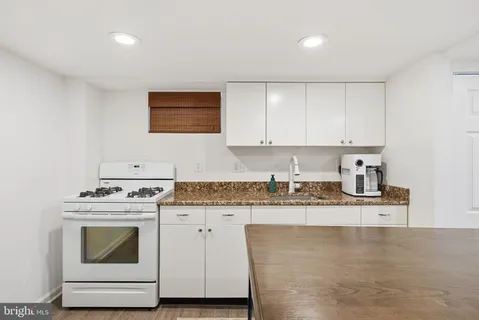a kitchen with granite countertop cabinets stainless steel appliances and a sink