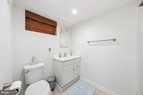 a bathroom with a toilet sink and mirror