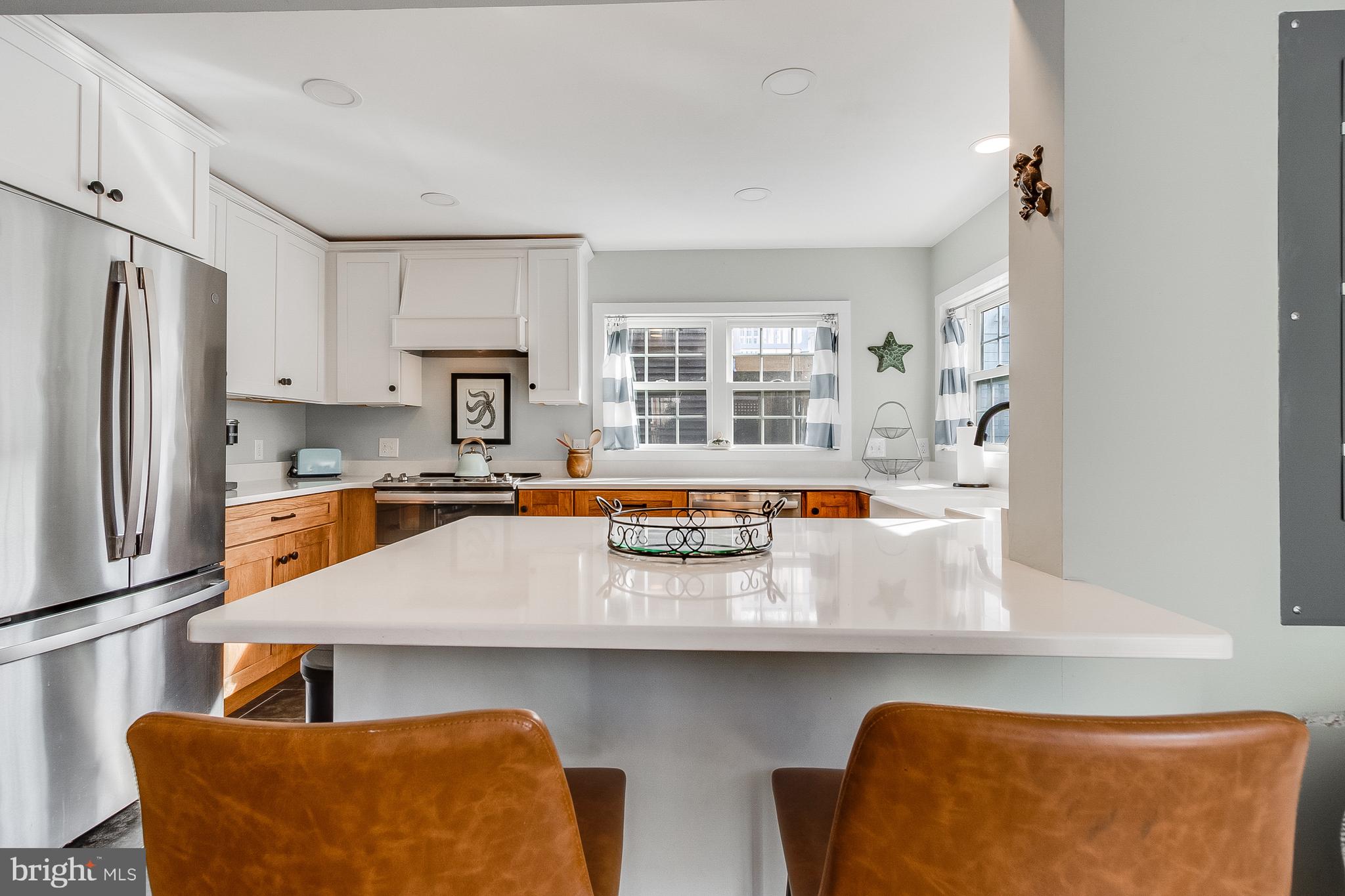 112 West 3rd Street Lewes, DE 19958 - Photo 26 of 73 a kitchen with stainless steel appliances granite countertop a sink and a refrigerator