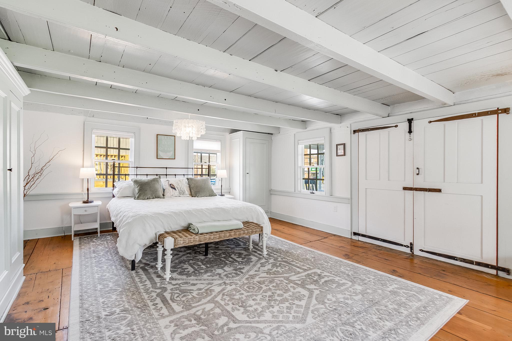 112 West 3rd Street Lewes, DE 19958 - Photo 32 of 73 a spacious bedroom with a large bed and a rug