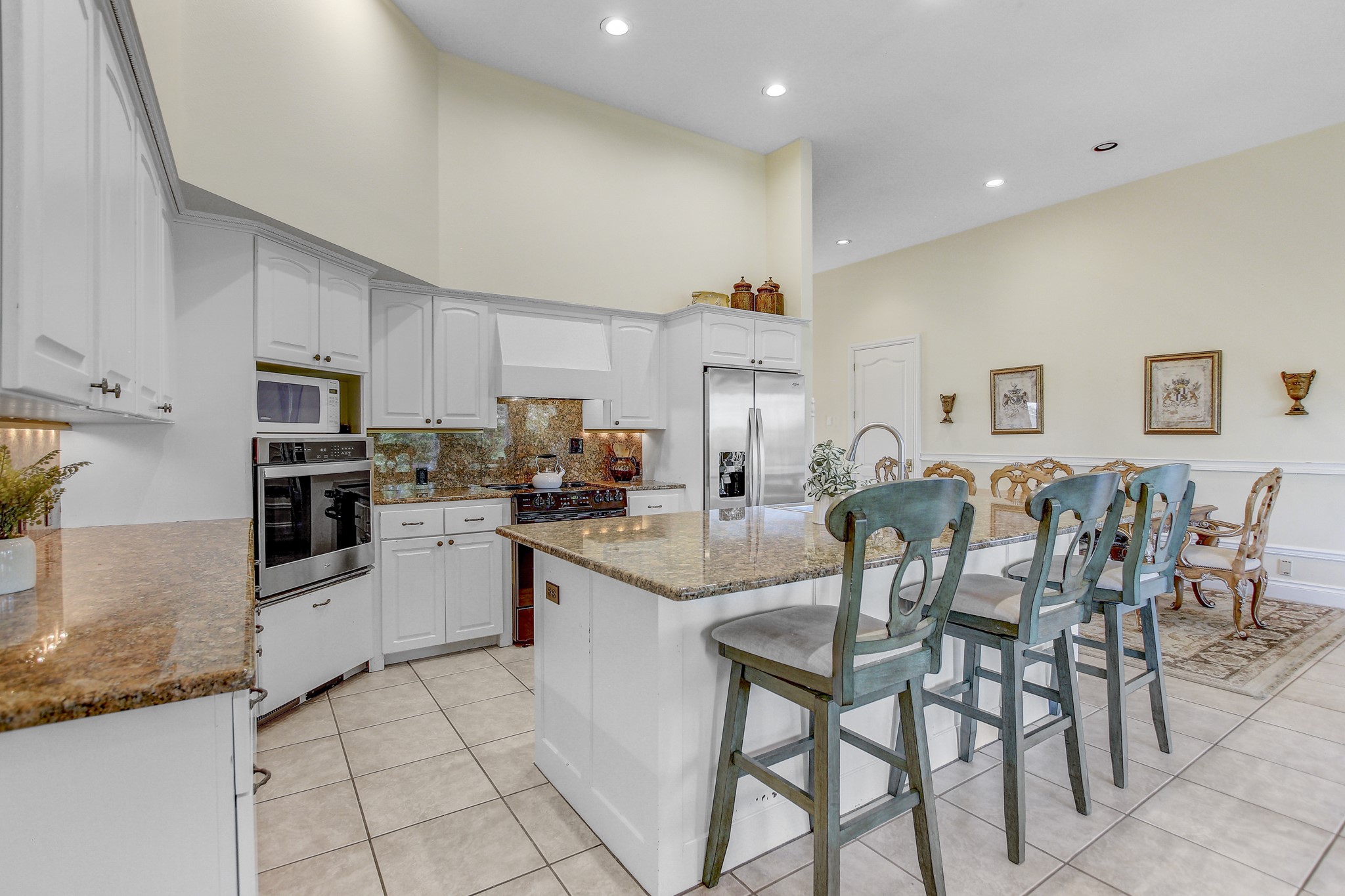 13628 Gregg Manor Road Manor, TX 78653 - Photo 18 of 33 a kitchen with stainless steel appliances granite countertop a table and chairs in it