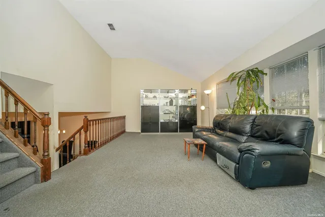 a living room with furniture and stairs