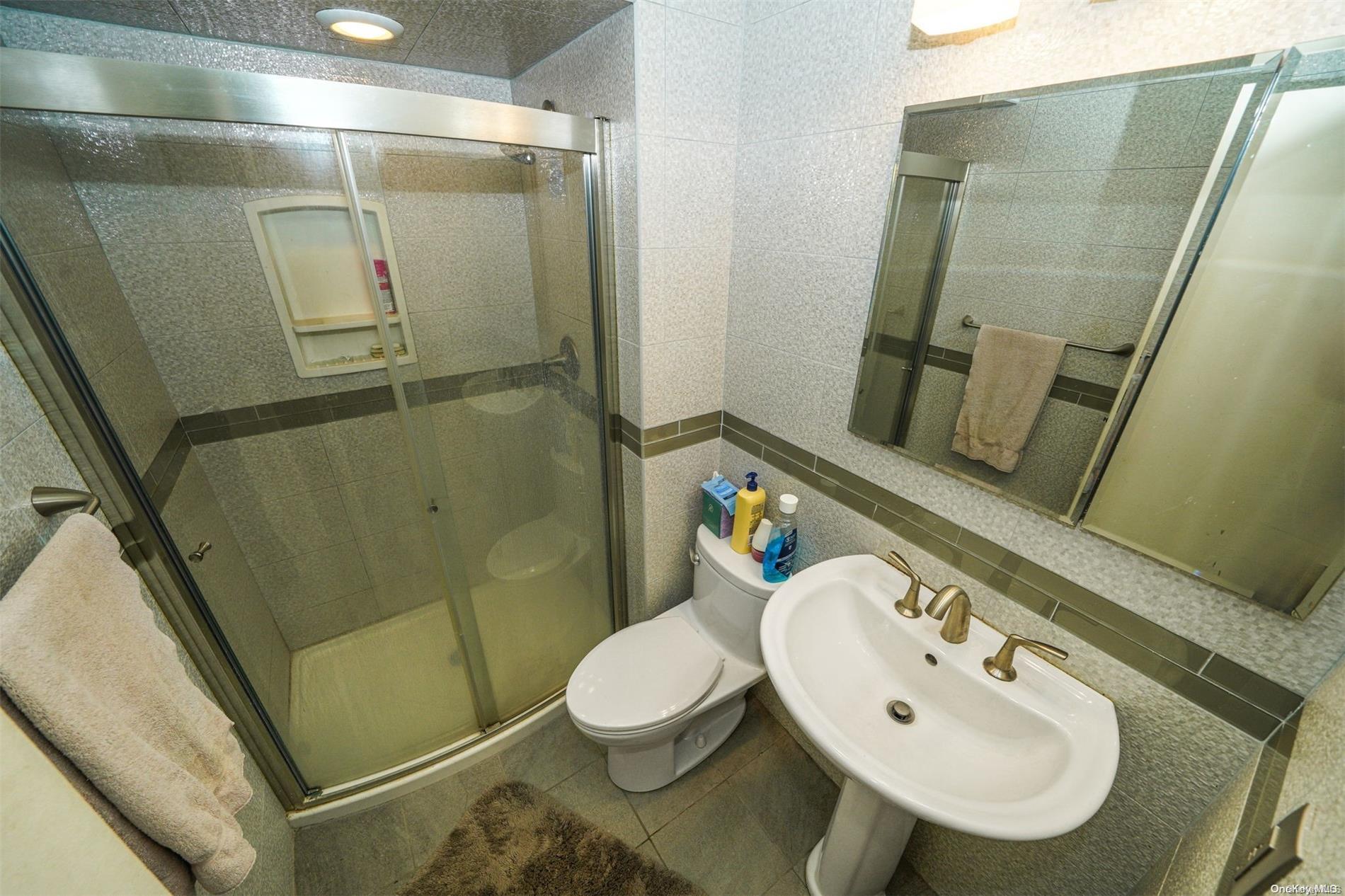 37 Santa Barbara Drive, Unit 37 Plainview, NY 11803 - Photo 16 of 32 a bathroom with a sink a toilet and shower