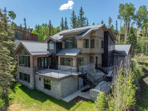 a front view of a house with swimming pool lawn chairs and a yard