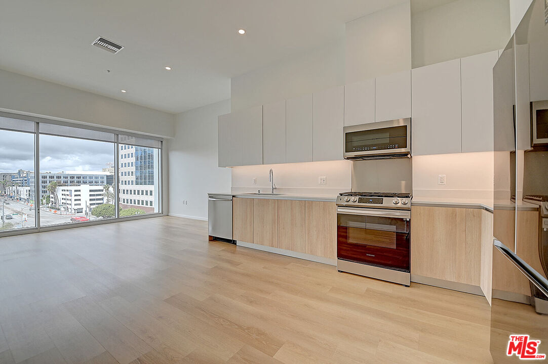200 West Ocean Boulevard, Unit 711 Long Beach, CA 90802 - Photo 2 of 21 a kitchen with stainless steel appliances a refrigerator and a stove