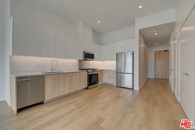 a kitchen with granite countertop a refrigerator and a sink