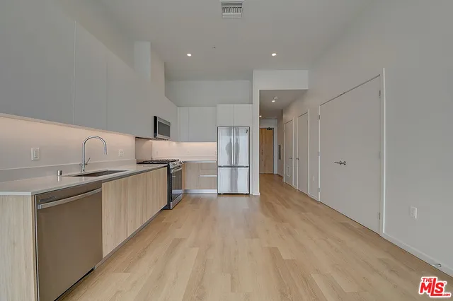 a kitchen with refrigerator and cabinets