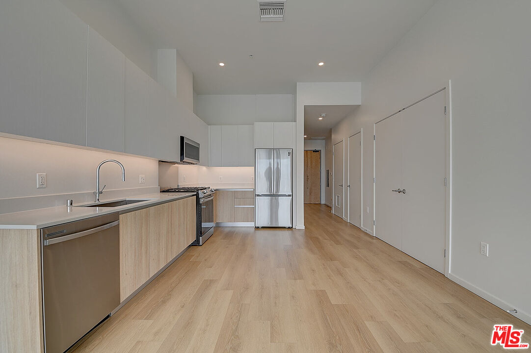 200 West Ocean Boulevard, Unit 711 Long Beach, CA 90802 - Photo 5 of 21 a kitchen with refrigerator and cabinets